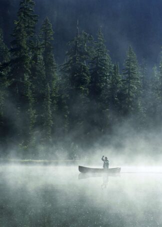 Man canoeing on lake covered with fog poster