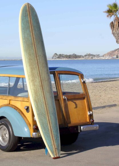 Surfboard beside the yellow car at the beach poster